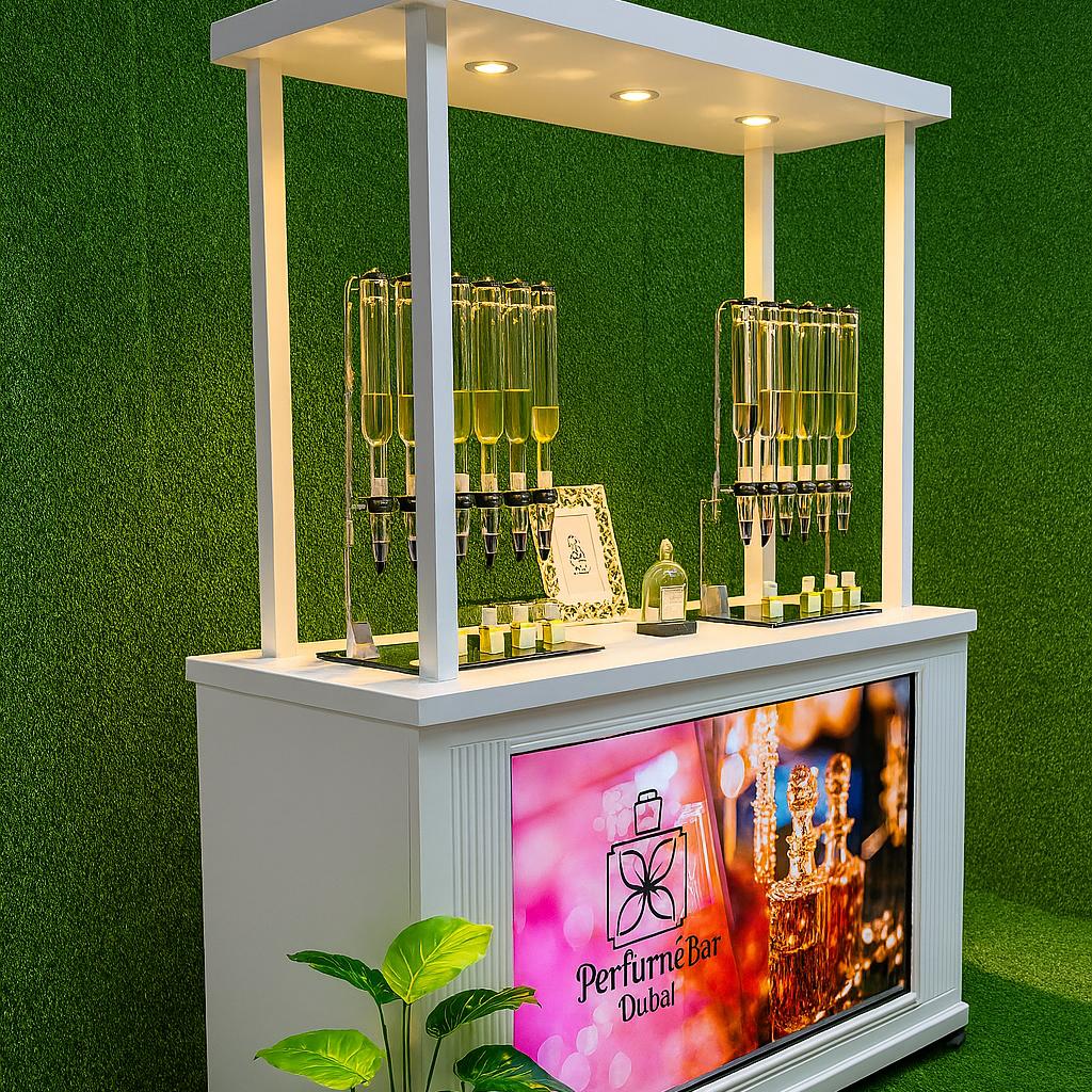 Perfume Booth setup in Dubai featuring a branded fragrance bar with colorful dispensers, interactive screen, and artificial grass backdrop for events and exhibitions